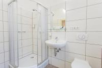 a white bathroom with a shower and a sink at Hotel &amp; Restaurant ,,Zur Alten Oder&quot; in Frankfurt-Oder in Frankfurt Oder