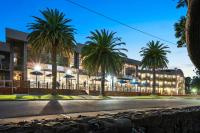a building with palm trees in front of a street at North Pier Hotel in Cowes