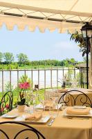 eine Gruppe von Tischen mit Stühlen und Blick auf das Wasser in der Unterkunft Logis Hôtel Le Relais Louis XI in Meung-sur-Loire