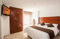 Un dormitorio con una cama grande y un televisor de pantalla plana. en Hotel Cafe y Miel, en Pasto