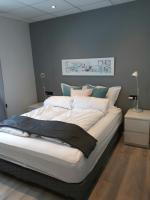 Un dormitorio con una gran cama blanca con paredes azules. en Post-Plaza Guesthouse, en Húsavík