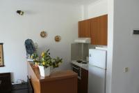 a kitchen with a white refrigerator and a table with a plant at Holiday Home by the Sea in Nea Potidaea