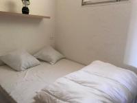 a white bed with two pillows in a room at Residence port la galere in Théoule-sur-Mer