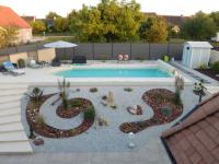 a backyard with a swimming pool and a landscaping at Audionnière in Saint-Gervais en-Belin