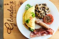 Un plato de desayuno con huevos, salchichas y champiñones. en Glenda's Guest Suites, en Midrand