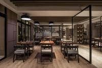 un restaurant avec des tables et des chaises en bois et des fenêtres dans l'établissement Courtyard by Marriott Siem Reap Resort, à Siem Reap