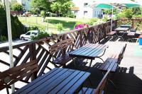 una fila de bancos y mesas de madera en una cubierta en Centrum Restauracyjno-Hotelowe Florres, en Pawłowiczki