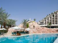 ein Swimmingpool mit einem Resort im Hintergrund in der Unterkunft Dan Eilat Hotel in Eilat