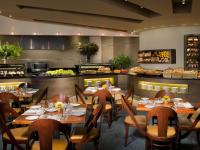 ein Restaurant mit Tischen und Stühlen und einer Küche in der Unterkunft Dan Eilat Hotel in Eilat