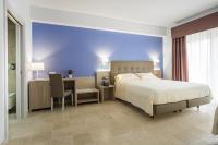 1 dormitorio con 1 cama extragrande, escritorio y mesa en Netum Hotel, en Noto