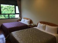 a hotel room with two beds and a window at 闕麒景觀民宿Chill Villa B&amp;B in Puli