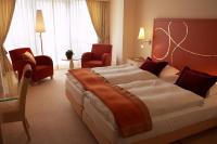 ein Hotelzimmer mit einem großen Bett und Stühlen in der Unterkunft Casino 2000 - Adult Guests Only in Mondorf-les-Bains