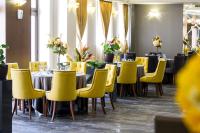 ein Esszimmer mit Tischen und gelben Stühlen in der Unterkunft Hotel Monte Cristo in Blagoewgrad