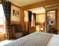 a bedroom with a bed and a chair at Auberge du Manoir in Chamonix