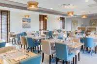 Un comedor con mesas y sillas azules. en Best Western le Sémaphore, en Rang-du-Fliers
