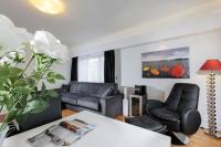 Una sala de estar con dos sillas y una mesa. en The Queen Luxury Apartments - Villa Carlotta, en Luxemburgo