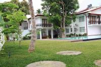 un edificio con una palmera frente a un patio en Serenity Tissa, en Tissamaharama