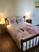 a bedroom with a bed with pink flowers on it at Gite chez Cyrano in Bergerac