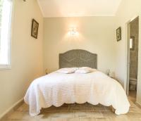 a bedroom with a bed with a white blanket at A jewel by the river! in Fontaine-de-Vaucluse