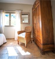 a room with a wooden cabinet and a chair and a window at A jewel by the river! in Fontaine-de-Vaucluse