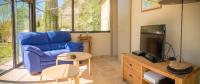 a living room with a blue couch and a tv at A jewel by the river! in Fontaine-de-Vaucluse