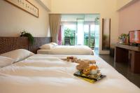 a hotel room with two beds and a tray of food on the bed at Luminous Hot Spring Resort &amp; SPA in Luye