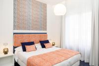 a bedroom with a large bed with blue and orange pillows at Hotel Nice in Sorrento