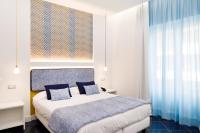 a bedroom with a bed with blue and white pillows at Hotel Nice in Sorrento