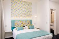 a bedroom with a large bed with blue pillows at Hotel Nice in Sorrento