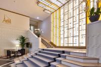 a lobby with stairs and a wall with a large window at Hotel &amp; Spa Vacances Bleues Le Splendid in Dax