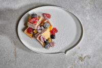 a plate with a piece of cake with berries on it at The Principal Madrid, Small Luxury Hotels in Madrid