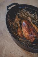 Una sartén con un pollo sobre una mesa en Le Barn, en Bonnelles