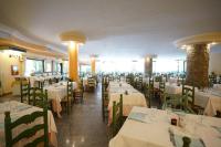 una sala da pranzo con tavoli e sedie con tovaglie bianche di Nicolaus Club Torre Moresca a Cala Liberotto