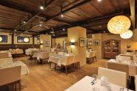 a restaurant with white tables and chairs and lights at Kreutzwald Hotel Tallinn in Tallinn