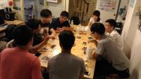 a group of people sitting around a table playing a game at Backpacker 41 Hostel - Kaohsiung in Kaohsiung