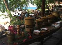 Una mesa con cuencos y platos con gente en un restaurante. en Koh Tao Cabana, en Ko Tao