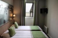 a hotel room with a bed and a window at Le Mouton Blanc in Le Mont Saint Michel