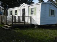 a white tiny house with a wooden porch at Mareva37 in Trogues