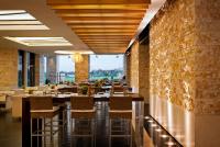 a restaurant with tables and chairs and a stone wall at VOGO Abu Dhabi Golf Resort & Spa Formerly The Westin Abu Dhabi Golf Resort & Spa in Abu Dhabi