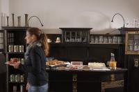 a woman standing in front of a counter with food at Hotel Burgfeld in Kassel