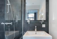 a bathroom with a sink and a shower at City2Beach Hotel in Vlissingen