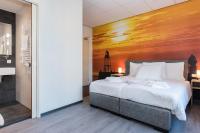 a bedroom with a large bed with a painting on the wall at City2Beach Hotel in Vlissingen