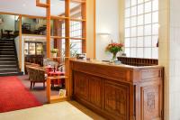 a lobby with a wooden podium with a vase of flowers at Logis Hôtel Des Châteaux De La Loire in Tours