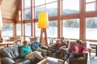 a group of people sitting on couches in a living room at Gîte du Mont-Albert - Sepaq in Sainte-Anne-des-Monts