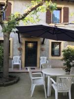 a table and chairs with an umbrella in front of a building at Villa Broglia House in Verona