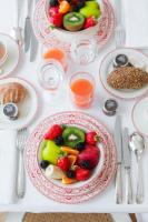 a table topped with plates of fruit and juice at Hôtel Alfred Sommier in Paris