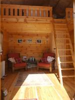 a log cabin with two chairs and a ladder at Le Chalet in Prémian