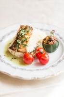 Un plato de comida con pescado y tomates encima. en La Maison De La Fontaine, Le Beny Bocage, en Le Bény-Bocage