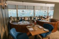 een restaurant met tafels en stoelen en uitzicht op het water bij Greenbank Hotel in Falmouth