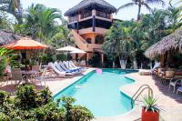 Un complejo con piscina y sillas y un edificio. en Hotel Casamar Suites, en Puerto Escondido
